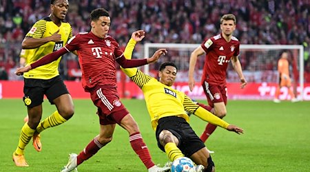 Münchens Jamal Musiala (2.v.l) und Dortmunds Jude Bellingham (2.v.r)kämpfen um den Ball. / Foto: Matthias Balk/dpa