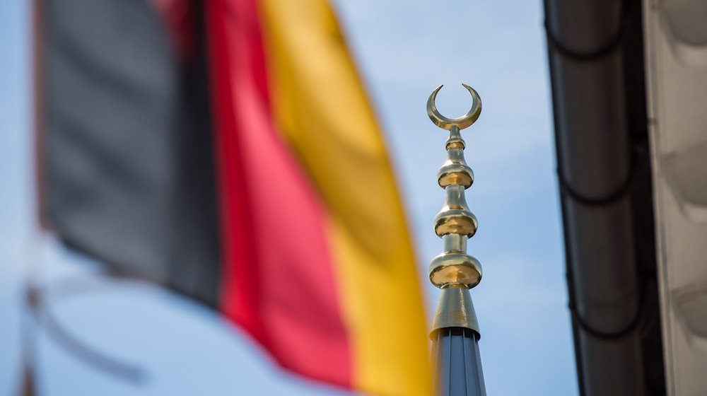 Die deutsche Fahne weht in Garmisch-Partenkirchen (Bayern) neben dem Minarett-Turm der Türkisch-Islamischen Gemeinde Garmisch-Partenkirchen. / Foto: Peter Kneffel/dpa