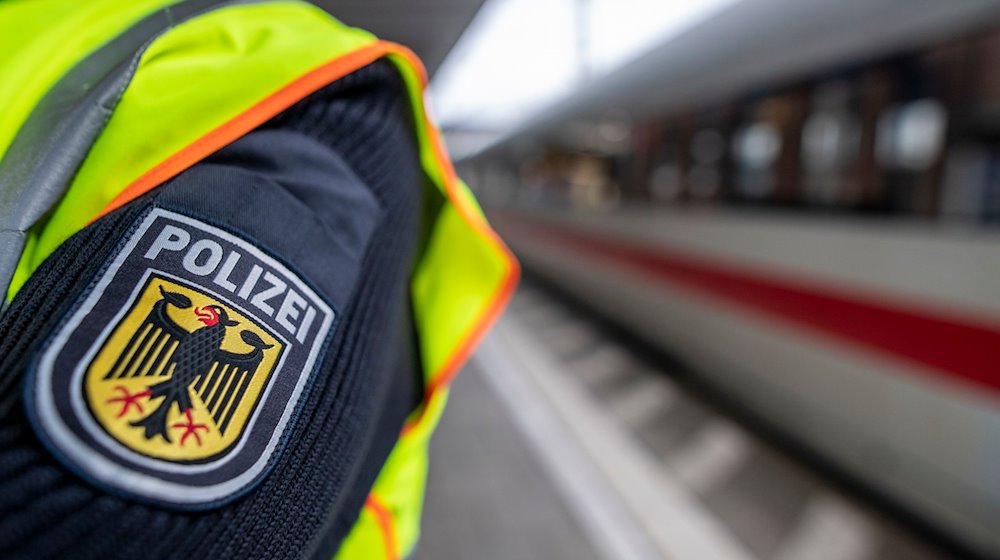 Ein Bundespolizist steht am Hauptbahnhof vor einem ICE. / Foto: Patrick Seeger/dpa