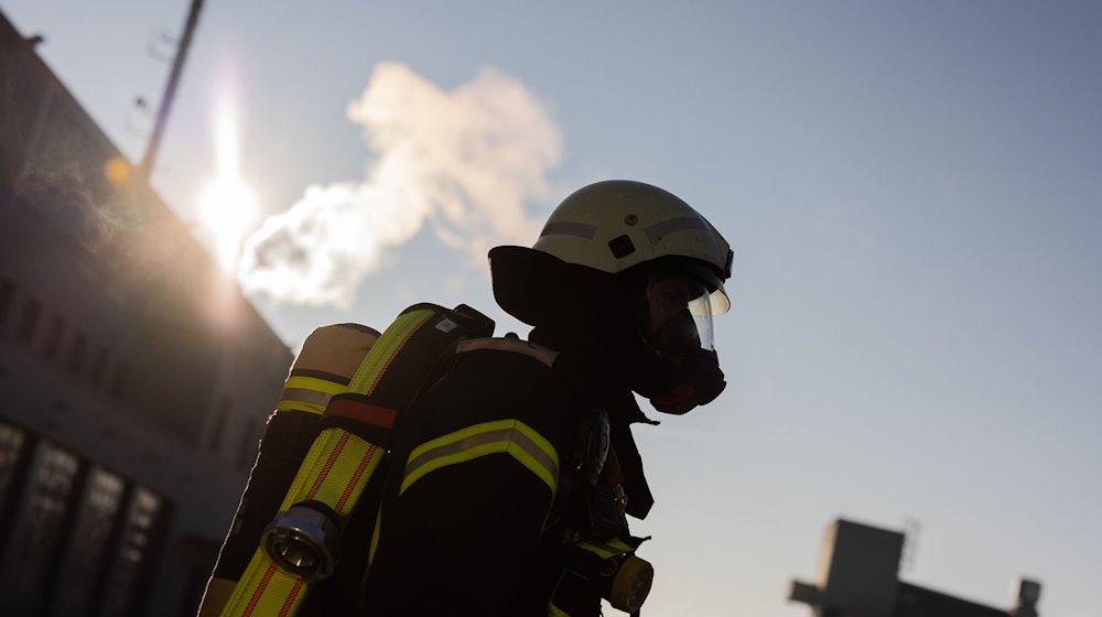 Ein Feuerwehrmann in Atemschutzausrüstung steht an einem Einsatzort. / Foto: Rolf Vennenbernd/dpa/Symbolbild