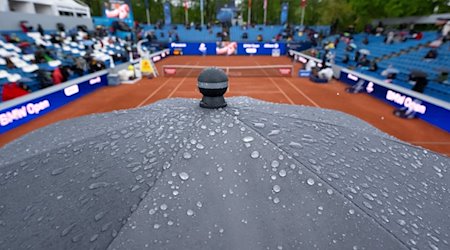 Zuschauer sitzen mit Regenschirmen auf der Tribüne. / Foto: Sven Hoppe/dpa