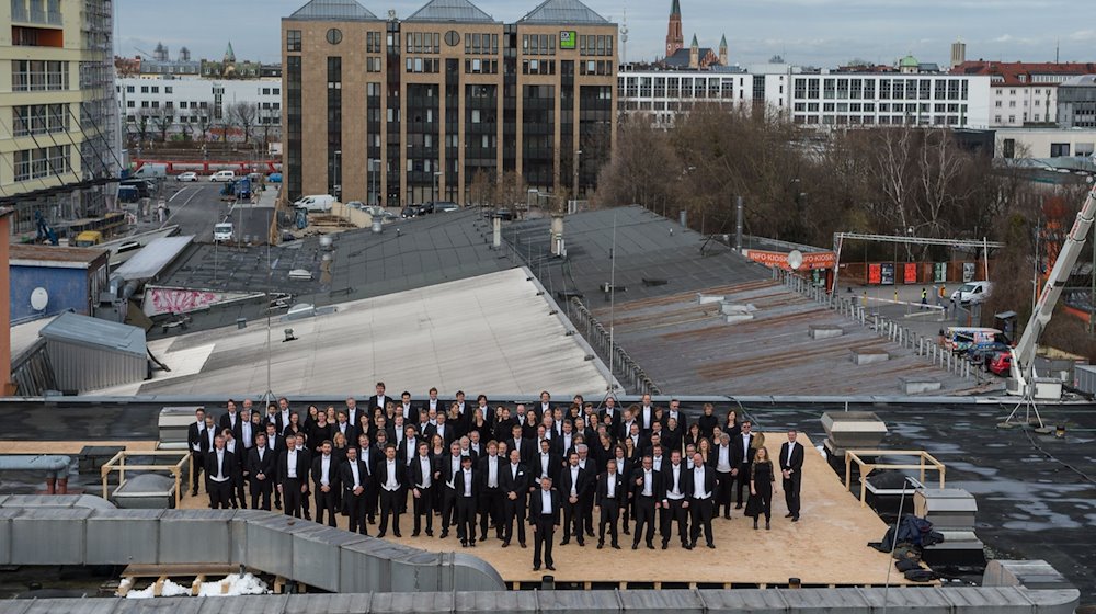 Die Musiker des Sinfonieorchesters des Bayerischen Rundfunks posieren für ein Gruppenfoto auf einem Dach an der Kultfabrik im Werksviertel. / Foto: Matthias Balk/dpa