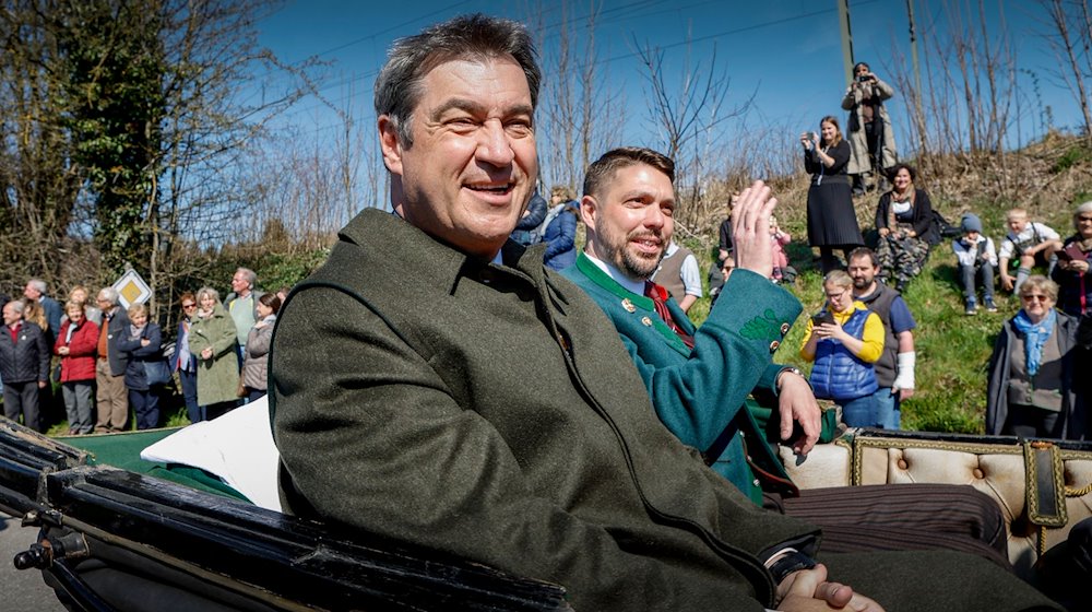 Bayerns Ministerpräsident Markus Söder (CSU, l) und Siegfried Walch (r) sitzen in einer Ehrenkutsche. / Foto: Uwe Lein/dpa/Archivbild