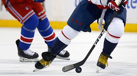 Zwei Eishockeyspieler kämpfen um den Puck. / Foto: John Munson/AP/dpa/Symbolbild