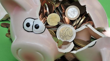Ein zerbrochenes Sparschwein mit Euromünzen. / Foto: Peter Kneffel/dpa