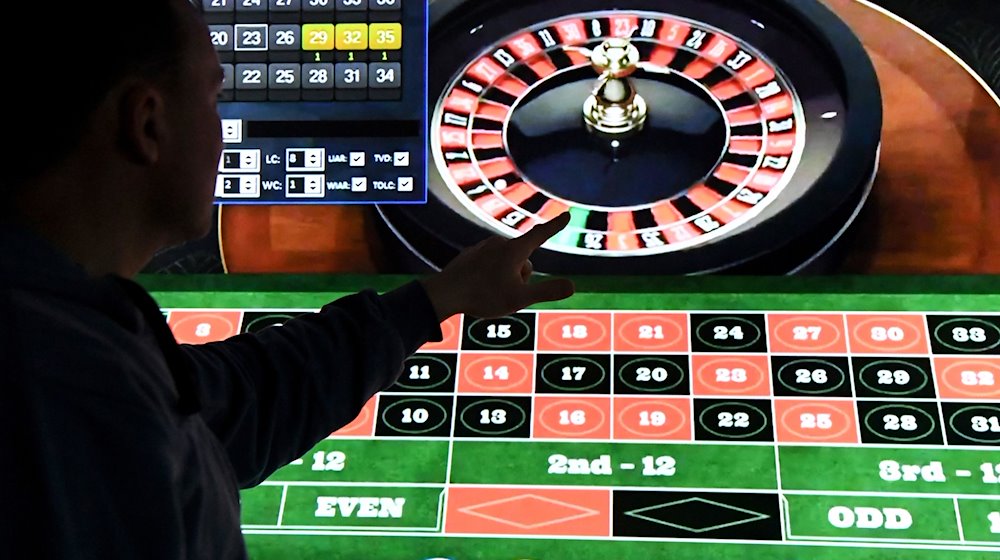 Ein Mann steht vor einem Bildschirm mit einer Seite für Online-Roulette. / Foto: Carsten Rehder/dpa/Archivbild