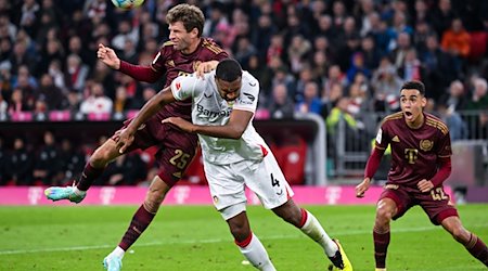 Thomas Müller (l) von München und Jonathan Tah von Leverkusen kämpfen um den Ball. / Foto: Sven Hoppe/dpa