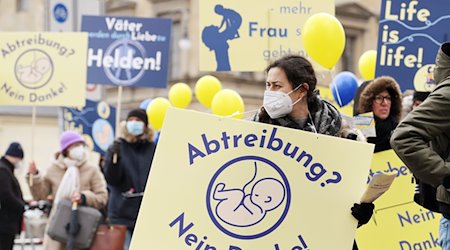 Eine Frau nimmt an einer Demonstration von Abtreibungsgegnern unter dem Titel "Marsch fürs Leben" teil und trägt ein Schild mit der Aufschrift "Abtreibung? Nein Danke!". / Foto: Tobias Hase/dpa