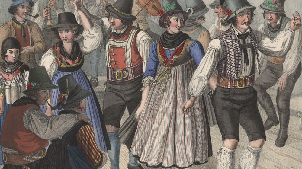 Eine kolorierte Lithographie aus der Zeit um 1825 mit dem Titel »Kirchweih-Tanz in der Umgegend von Tegernsee« zeigt Menschen in zeitgenössischer Tracht beim Tanz. / Foto: Bezirk Oberbayern/Sammlung Bayerischer National-Costüme/dpa