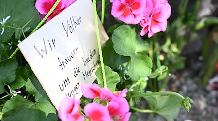 Neben dem Einkaufszentrums an dem am Samstagabend zwei Männer aus der Ukraine getötet worden sind, haben Menschen Blumen und Plakate niedergelegt. Die beiden getötete Ukrainer waren Armeeangehörige. / Foto: Angelika Warmuth/dpa