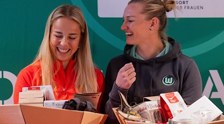 Alexandra Popp (l) vom VfL Wolfsburg und Giulia Gwinn vom FC Bayern München lachen miteinander bei einem Gespräch im Deutschen Sport und Olympiamuseum. / Foto: Rolf Vennenbernd/dpa