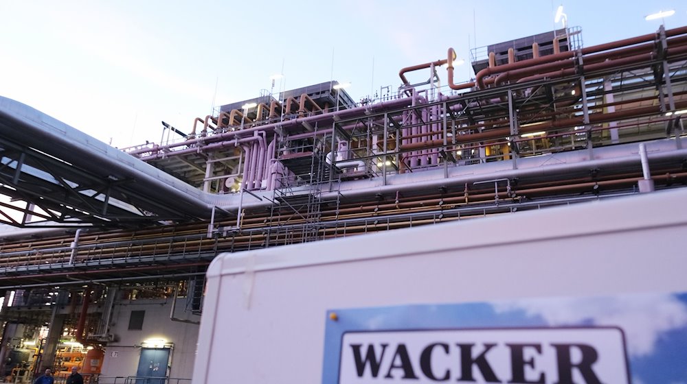 Eine Schautafel mit der Aufschrift «Wacker» steht vor einer Anlage auf dem Gelände der Wacker Chemie Nünchritz. / Foto: Sebastian Willnow/Deutsche Presse-Agentur GmbH/dpa