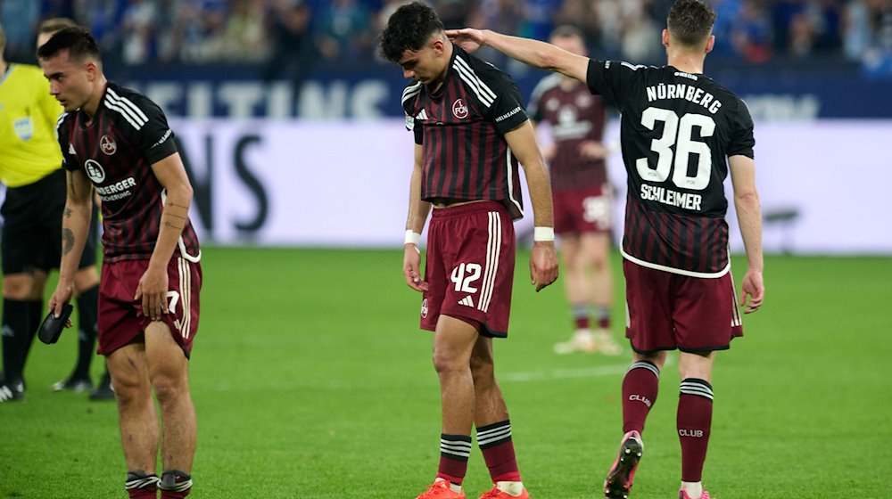 Jens Castrop, Can Uzun und Lukas Schleimer (l-r) von Nürnberg zeigen sich nach dem Spiel enttäuscht. / Foto: Bernd Thissen/dpa