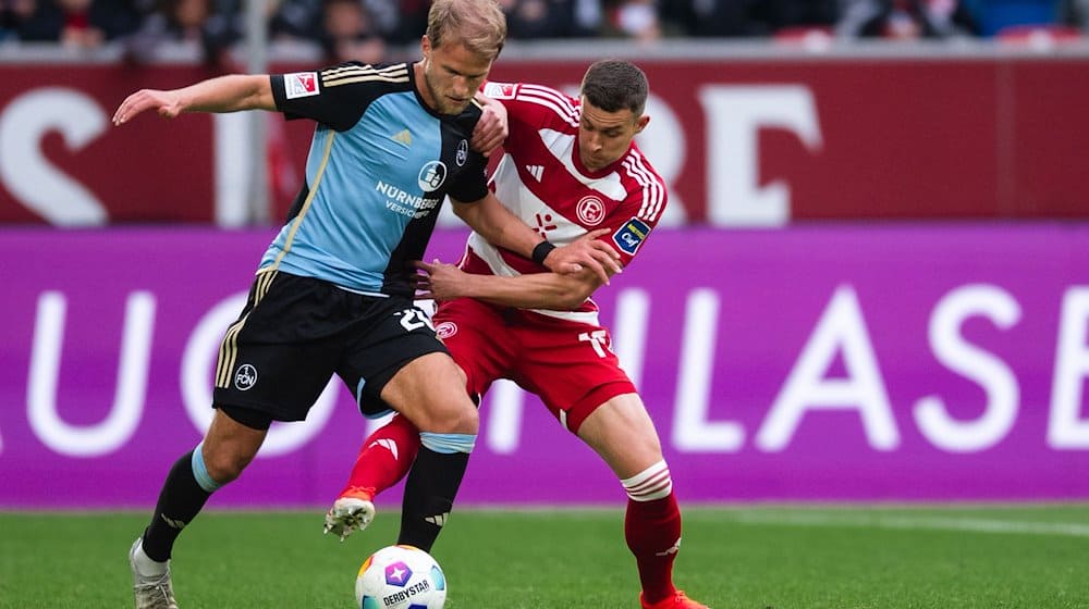 Düsseldorfs Tim Oberdorf (r) und Nürnbergs Sebastian Andersson kämpfen um den Ball. / Foto: Marius Becker/dpa