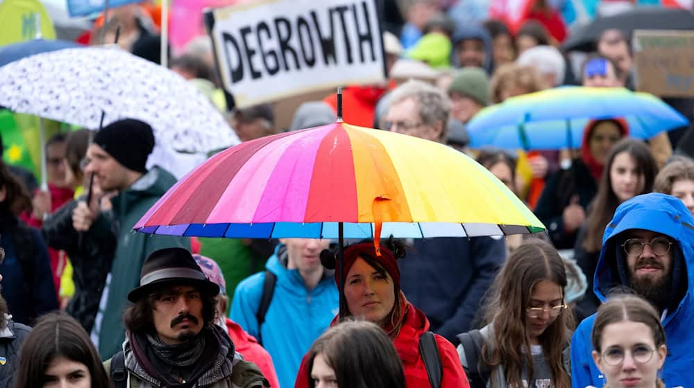 Zahlreiche Menschen nehmen auf dem Königsplatz an einer Demonstration zum Klimastreik teil und halten ein Plakat mit der Aufschrift „DEGROWTH“ in die Höhe. / Foto: Sven Hoppe/dpa