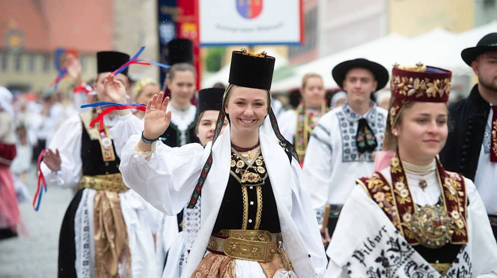 In traditioneller Tracht laufen Teilnehmer eines Trachtenumzuges der Siebenbürger Sachsen durch die Altstadt von Greding. / Foto: Timm Schamberger/dpa