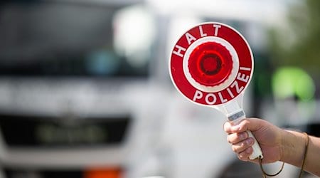 Ein Polizist hält bei einer Verkehrskontrolle eine Polizeikelle in der Hand. / Foto: Jonas Güttler/dpa/Symbolbild