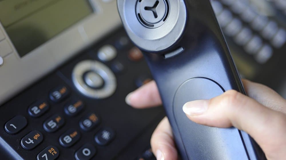 Eine Frau hält einen Telefonhörer in der Hand. / Foto: Marc Müller/dpa/Symbolbild