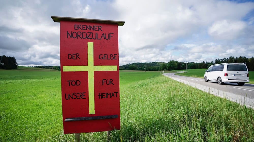 Ein Protestschild mit der Aufschrift «Brenner Nordzulauf - Der gelbe Tod für unsere Heimat» einer Bürgerinitiative steht auf einer Wiese der geplanten Bahntrasse. / Foto: Uwe Lein/dpa