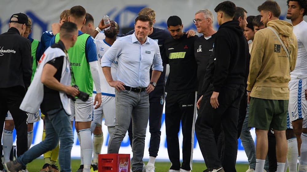 Magdeburgs Trainer Christian Titz steht nach dem Spiel bei seinen Spielern auf dem Feld. / Foto: Swen Pförtner/dpa