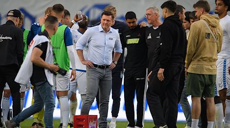 Magdeburgs Trainer Christian Titz steht nach dem Spiel bei seinen Spielern auf dem Feld. / Foto: Swen Pförtner/dpa