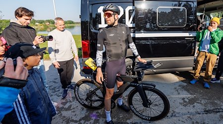 Extremsportler Jonas Deichmann (M) startet auf dem Rad seines Thiathlons die Radetappe. / Foto: Daniel Karmann/dpa