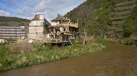 Ein abbruchreifes Haus, das durch die Flut zerstört wurde, steht an einem Ufer. / Foto: Thomas Frey/dpa/Archivbild