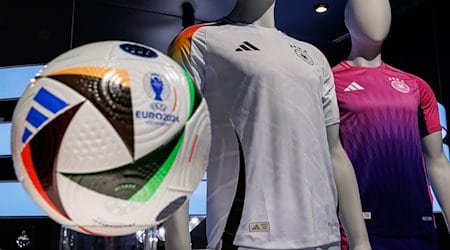 Die offiziellen Trikots der deutschen Fußball-Nationalmannschaft für die kommende Fußball-Europameisterschaft 2024 (UEFA EURO 2024) und der offizielle Spielball sind am Sitz des Sportartikelherstellers adidas AG zu sehen. / Foto: Daniel Karmann/dpa