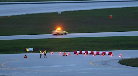 Klimaaktivisten haben sich am frühen Morgen auf einer Zufahrt für Start- und Landebahnen am Flughafen Franz-Josef-Strauß festgeklebt. / Foto: Karl-Josef Hildenbrand/dpa