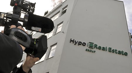 Ein Kameramann steht vor der damaligen Zentrale der Hypo Real Estate (HRE). / Foto: Peter Kneffel/dpa/Archivbild