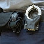 Handschellen stecken in der Gürtelhalterung eines Justizbeamten. / Foto: Friso Gentsch/dpa/Symbolbild