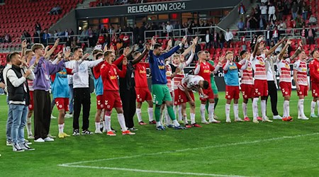 Die Regensburger stehen nach dem Spiel vor ihrer Fankurve. / Foto: Daniel Löb/dpa