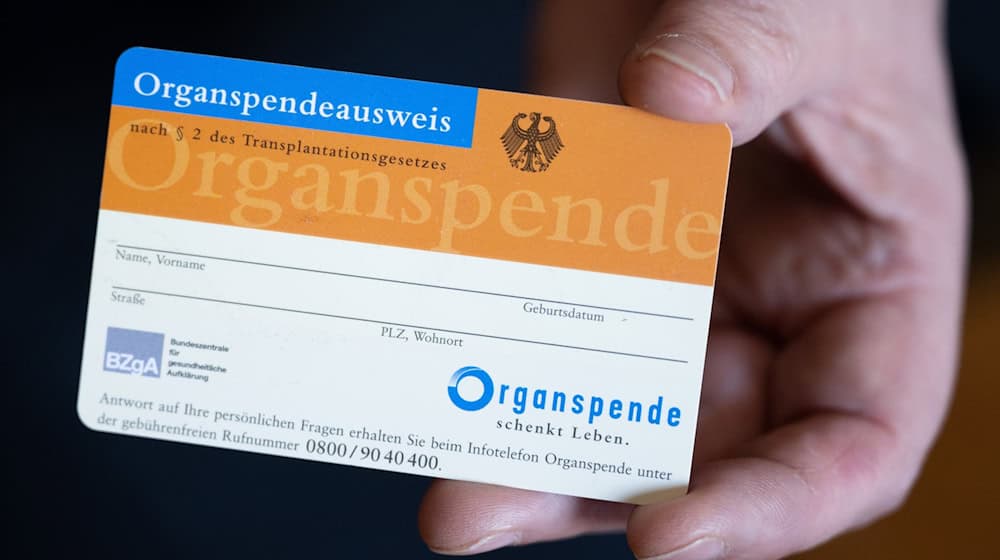 Eine Frau hält einen Organspendeausweis in der Hand. / Foto: Hendrik Schmidt/dpa