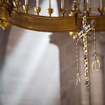 Ein Kreuz hängt an einem Leuchter im Altarbereich des Bamberger Doms. / Foto: Daniel Vogl/dpa