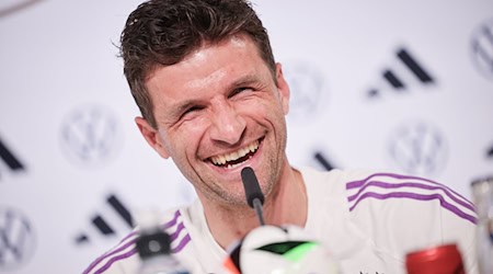 Thomas Müller lacht auf der Pressekonferenz. / Foto: Christian Charisius/dpa