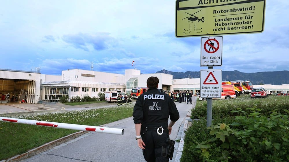 Polizisten und Einsatzkräfte der Feuerwehr stehen vor der abgeriegelten Notaufnahme des Unfallklinikums Murnau. / Foto: Karl-Josef Hildenbrand/dpa