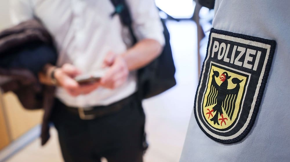 Ein Beamter der Bundespolizei kontrolliert einen Mann. / Foto: Christian Charisius/dpa/Symbolbild