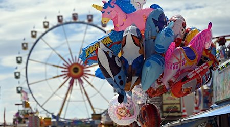 Besucher des Frühlingsfests gehen über die Theresienwiese in München. / Foto: Niklas Treppner/dpa