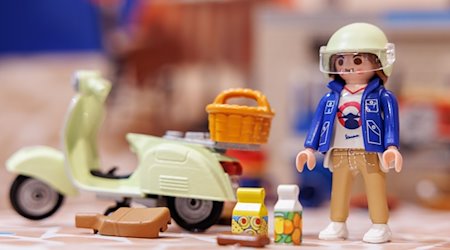 Eine Playmobil-Figur mit Vespa aus der Kidult-Reihe steht im Vorfeld der Spielwarenmesse am Stand von Playmobil. / Foto: Daniel Karmann/dpa