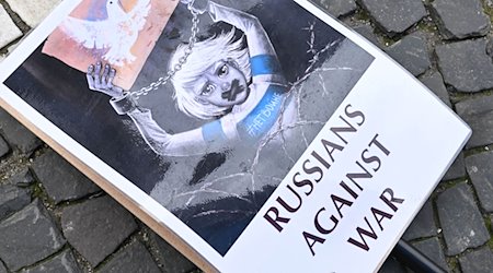 Ein Schild mit der Aufschrift «Russians against war» liegt auf dem Odeonsplatz in München auf dem Boden. / Foto: Felix Hörhager/dpa