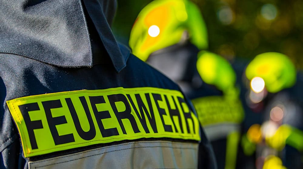 Feuerwehrleute stehen zusammen, um den Einsatz zu besprechen. / Foto: David Inderlied/dpa/Symbolbild