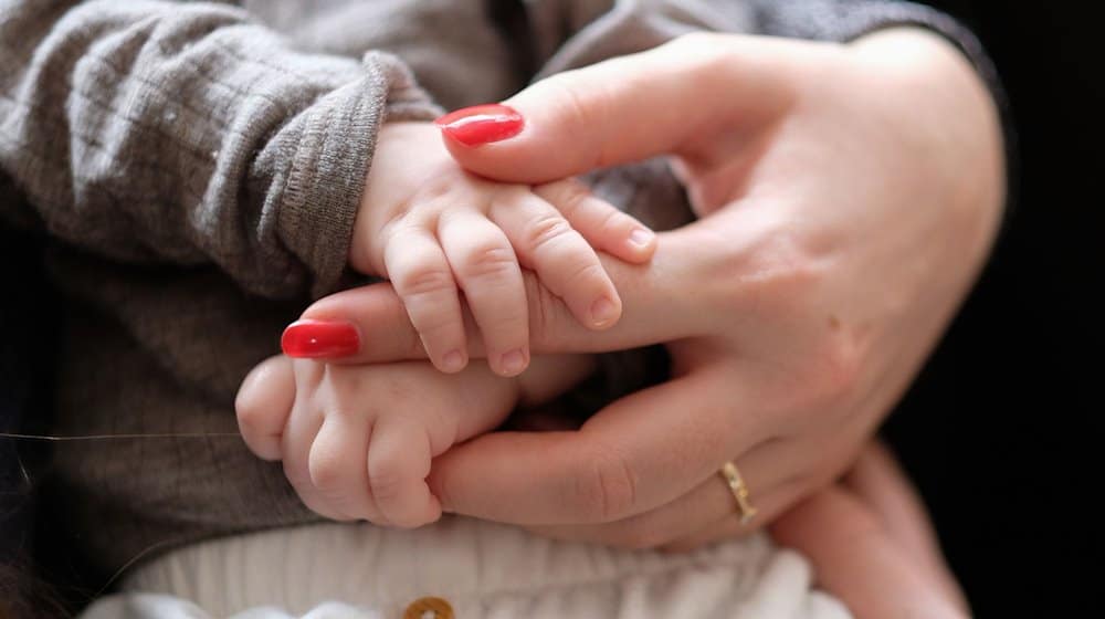 Eine Frau hält ein zwei Monate altes Baby im Arm. / Foto: Bernd Weißbrod/dpa/Symbolbild