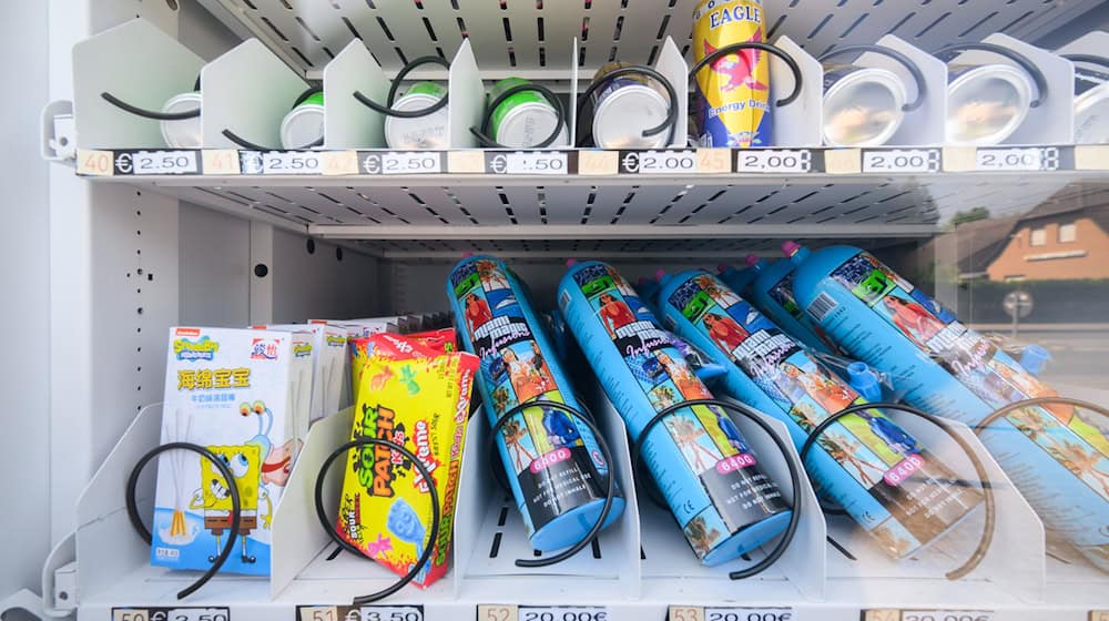Ein Warenautomat, unter anderem mit Lachgasflaschen bestückt, steht vor einem Ladengeschäft. Aus Luftballons eingeatmetes Lachgas hat sich zur Partydroge unter jungen Leuten entwickelt. / Foto: Julian Stratenschulte/dpa
