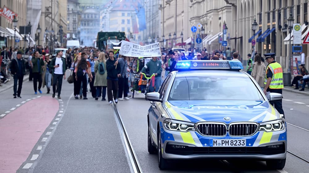 Ein Polizeiauto fährt vor den Teilnehmenden der Demonstration «Krachparade» durch die Maximilianstraße. / Foto: Felix Hörhager/dpa