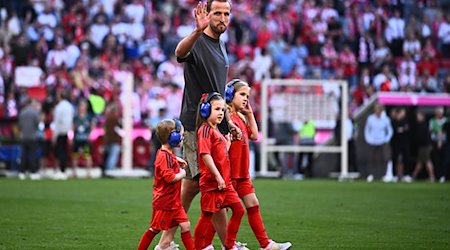 Münchens Harry Kane geht mit Kindern nach dem Spiel auf dem Spielfeld. / Foto: Tom Weller/dpa