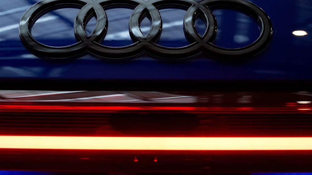 Das Logo von Audi ist vor Beginn der Jahrespressekonferenz an einem Auto in der Firmenzentrale zu sehen. / Foto: Sven Hoppe/dpa