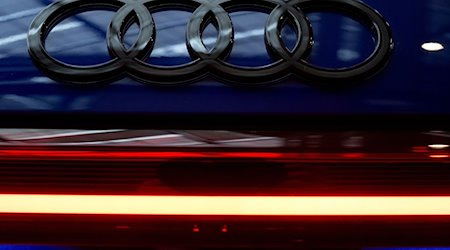 Das Logo von Audi ist vor Beginn der Jahrespressekonferenz an einem Auto in der Firmenzentrale zu sehen. / Foto: Sven Hoppe/dpa