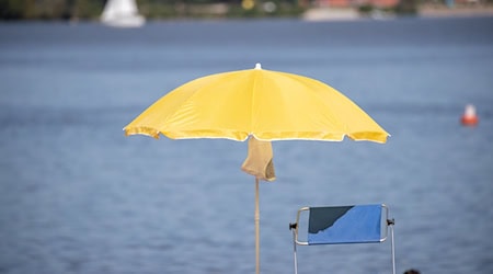 Ein Sonnenschirm steht an einem Strand am Altmühlsee. / Foto: Daniel Karmann/dpa