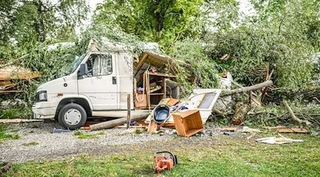 Umgestürzte Bäume und Äste liegen auf einem Wohnwagen auf einem Campingplatz in Lindau. / Foto: Jason Tschepljakow/dpa