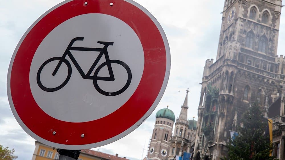 Ein «Radfahren verboten»-Verkehrsschild ist in der Innenstadt vor der Kulisse der Frauenkirche und des Rathauses zu sehen. / Foto: Peter Kneffel/dpa